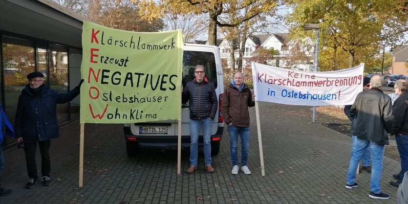 Menschen mit Plakaten demonstrieren gegen Klärschlammverbrennung.