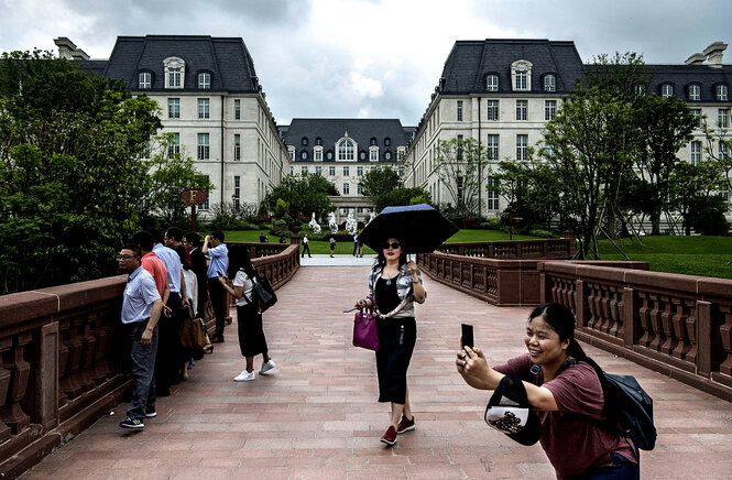 Menschen fotografieren vor einem Nachbau des Schlosses Versailles auf dem Firmengelände von Huawei in Shenzhen