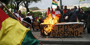 Angezündete bolivianische Fahnen am Straßenrand