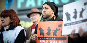 Ferat Kocak hält ein Schild: "Berlin gegen Nazis"