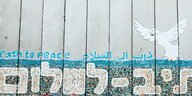 Ein Stück Mauer, auf dem auf hebräisch, arabisch und englisch "Weg zum Frieden" steht