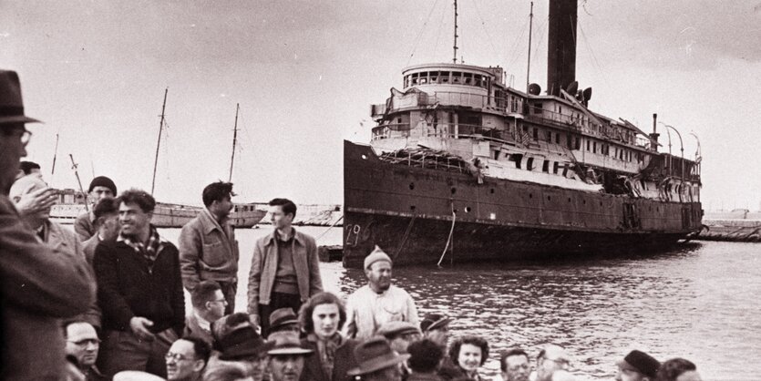 EIn historisches Bild: EIn Schiff legt an einem Hafen an.