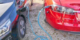 Detailaufnahme zweier Elektroautos, die an einer Ladestation aufgetankt werden