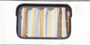 Fenster eines Wohnwagens mit geschlossenem Vorhang