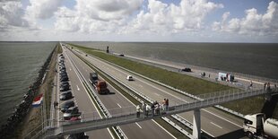 Autobahn auf einem Deich durch Wasser.