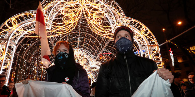 Junge leute mit halb verdeckten Gesichtern demonstrieren in Minsk