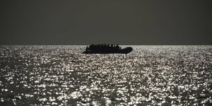 Migranten sitzen in einem Schlauchboot vor der Küste Libyens.