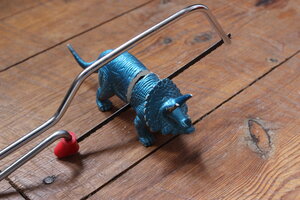 Ein blauer Gummidino wird mit einer Laubsäge geteilt Ein blauer Gummidino wird mit einer Laubsäge geteilt