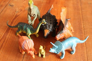 Mehrere Gummidinos stehen auf einem Dielenboden Mehrere Gummidinos stehen auf einem Dielenboden