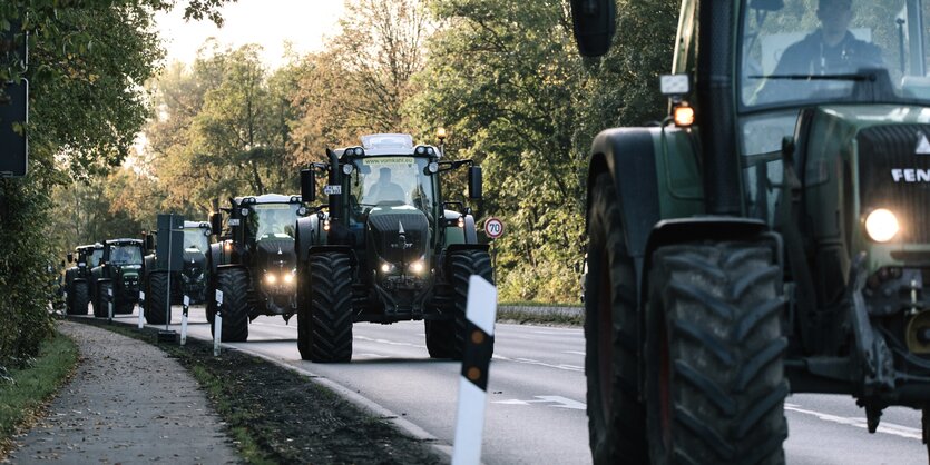 Eine Kolonne von Traktoren auf einer Landstraße.