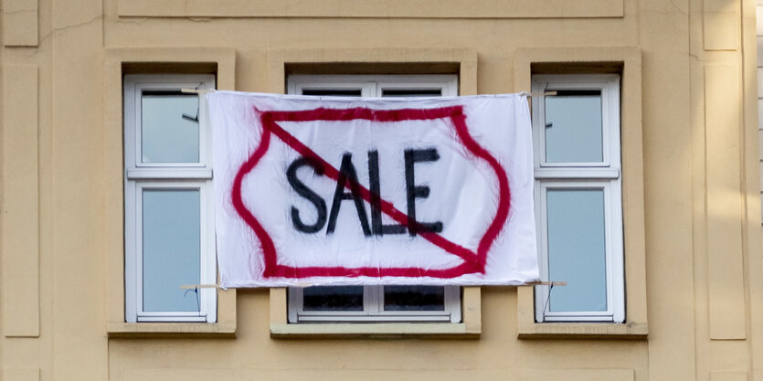 Plakate hängen an der Fassade eines Hauses