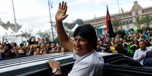 Evo Morales steigt in ein Auto, Menschen jubeln ihm zu