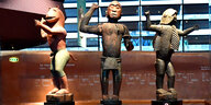 Drei afrikanische Statuen stehen in einem Museum