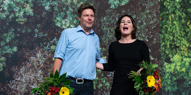Die beiden wiedergewählten Bundesvorsitzenden von Bündnis 90/Die Grünen, Robert Habeck und Annalena Baerbock, stehen beim Bundesparteitag der Grünen mit Blumen auf der Bühne.