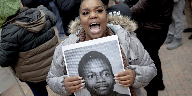 Eine Demonstrantin hält ein Foto von Rodney Reed