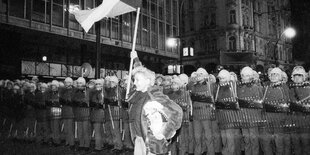 Viele Polizisten und eine Demonstrantin mit Flagge