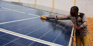 Ein Techniker reinigt Solarpaneele