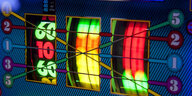 Ein Spielautonmat, wie sie oft in Casinos stehen, leuchtet bunt.