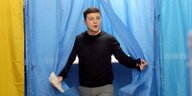 Ein Mann durchschreitet einen blauen Vorhang