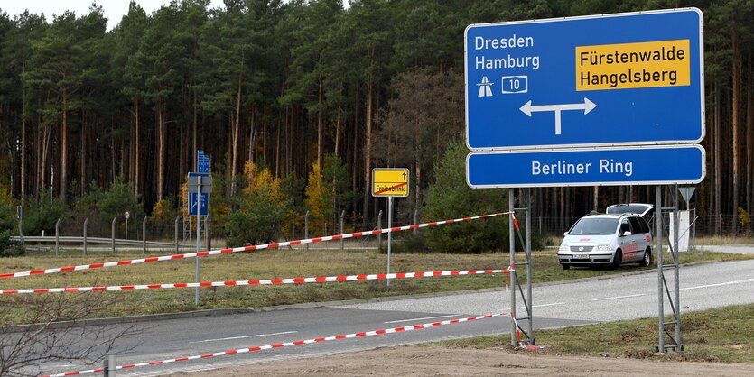 Eine Straße im brandenburgischen Nirgendwo. Absperrband spannt sich von einem Autobahnauffahrtsschild in die Gegend. Es ist trostlos und dann steht dahinter auch noch ein Wald