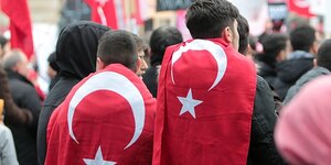 Zwei Männer haben sich Türkeifahnen umgehängt und demonstrieren