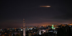 Stadt in der Nacht, eine Rakete fliegt