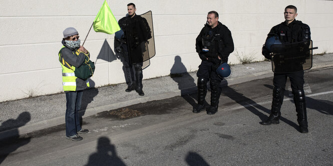 Frau in gelber Weste und Polizisten