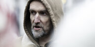 Roger Hallam mit Kapuze und grauem Bart vor verschwommenen Hintergrund