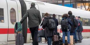 Leute am Bahnsteig warten darauf, in einen ICE einzusteigen