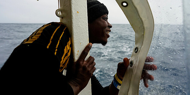 ein Migrant blickt auf die Küste von Sizilien
