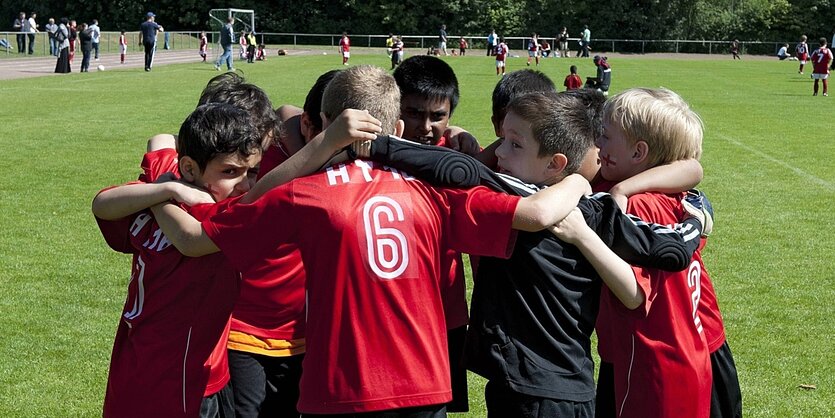 eine Jungen-Fussballmannschaft hat sich im Kreis aufgestellt