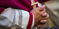 Zum Gebet gefaltete Hände eines Bischofs.