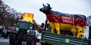 Eine Kuh aus Plastik steht auf einem LKW