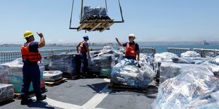 Paletten mit Kokain werden auf ein Schiff verladen