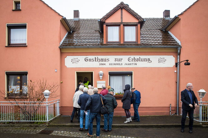 Eine Menschenmenge vor einem Gasthaus