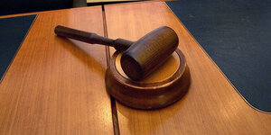 Ein Richterhammer liegt auf einem Holztisch