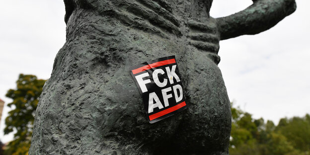Ein Aufkleber mit der Aufschrift "FCK AFD" klebt auf einer Skulptur im Park am Berliner Planetarium.