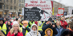 Menschen nehmen auf dem Opernplatz an einer Demonstration gegen die Pflegekammer teil.