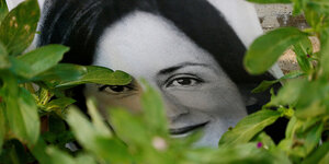 Eine Foto der getöteten Journalisten Daphne Caruana Galizia zwischen Blumen