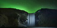 Ein Wasserfall unter grün erleuchtetem Nachthimmel