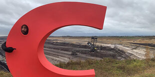 Greenpeace-Aktivist mit dem Buchstaben "C" vor dem Braunkohletagebau in Garzweiler