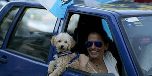 In Feierlaune: Eine Unterstützerin von Luis Lacalle Pou samt Hund in einem Auto in Montevideo