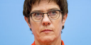 Portrait von Annegret Kramp-Karrenbauer vor blauem Hintergrund