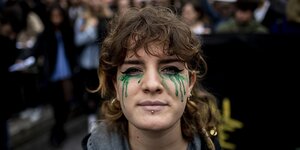 Demonstrantin mit grüner Tränenschminke