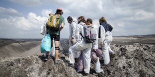 Eine Gruppe von Menschen steht in einer Mondlandschaft