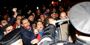 Demonstranten bedrängen eine Polizeiabsperrung.