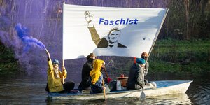 Mehrere Personen fahren mit einem Boot und halten ein Protest in die Höhe, auf dem der Thüringer AfD-Politiker Björn Höcke zu sehen ist. Darüber steht Faschist geschrieben.
