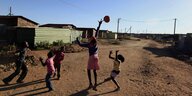 Kinder spielen in einm Dorf Ball