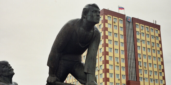 Ein sozialistisches Denkmal zweier Männer, dahinter ein Plattenbau