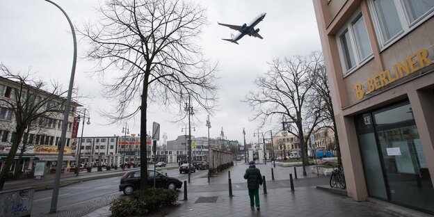 Ein flugzeug fliegt dicht über den Kurt-Schumacher-Platz in Berlin-WEdding